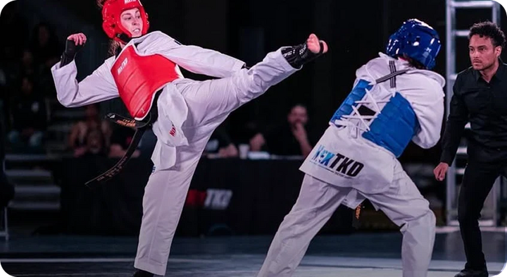 Taekwondo athletes in doboks kicking during sparring